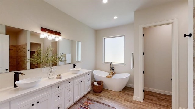 bathroom with vanity, a bath, and hardwood / wood-style flooring