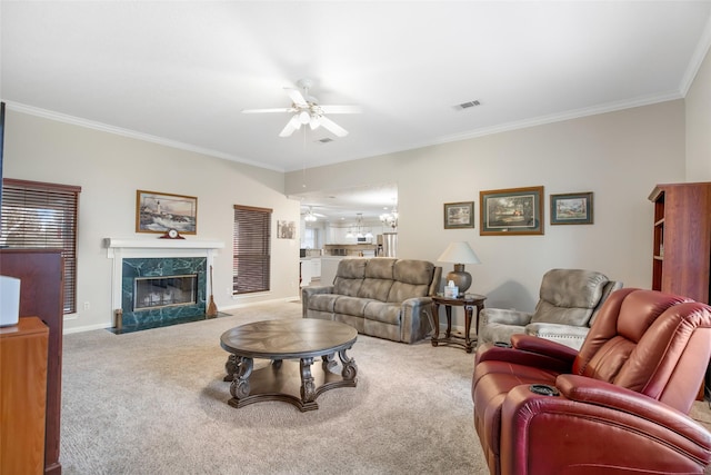 carpeted living room with ceiling fan, ornamental molding, and a premium fireplace