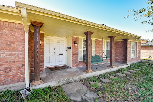 view of exterior entry featuring covered porch