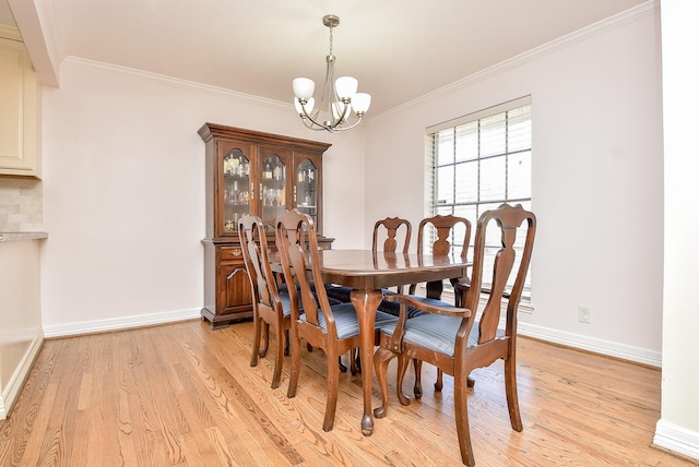 dining room with a notable chandelier, light hardwood / wood-style floors, and ornamental molding