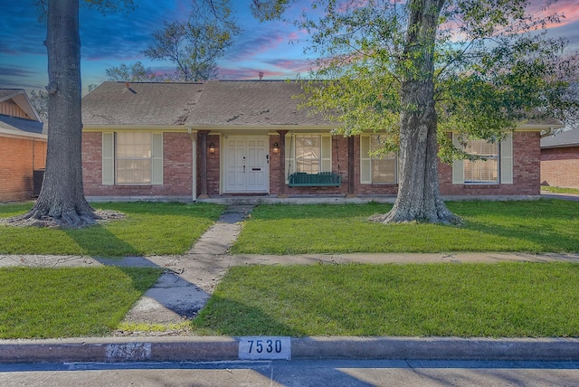 single story home featuring a lawn and central AC unit