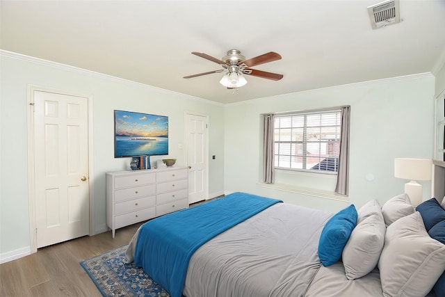 bedroom featuring light hardwood / wood-style floors, ceiling fan, and ornamental molding