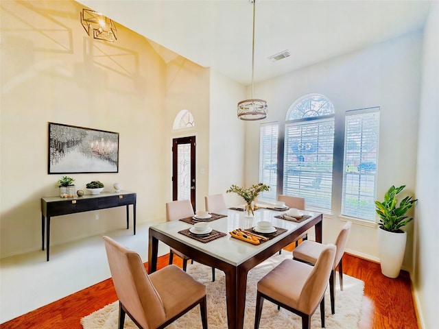 dining space featuring hardwood / wood-style floors and an inviting chandelier