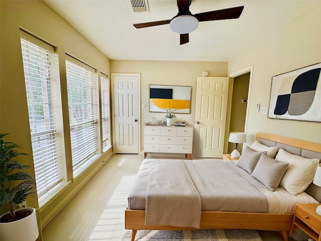 bedroom featuring multiple windows, ceiling fan, and light hardwood / wood-style floors