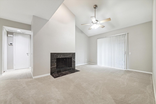 unfurnished living room with ceiling fan, lofted ceiling, a fireplace, and light carpet