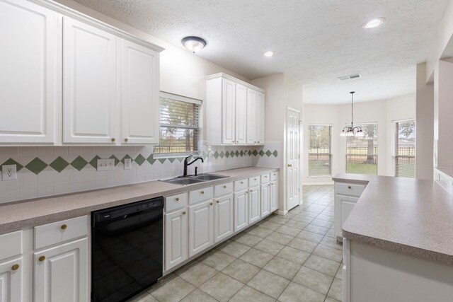 kitchen with white cabinets, sink, black dishwasher, and an inviting chandelier