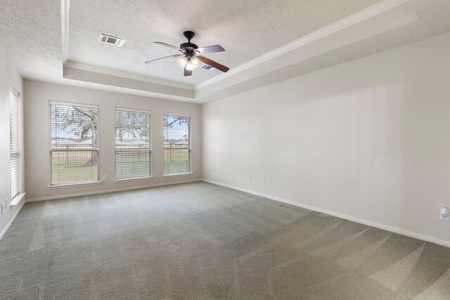 unfurnished room with a textured ceiling, a tray ceiling, ceiling fan, and ornamental molding