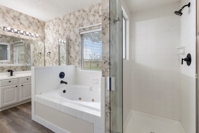 bathroom with hardwood / wood-style floors, vanity, separate shower and tub, and a textured ceiling