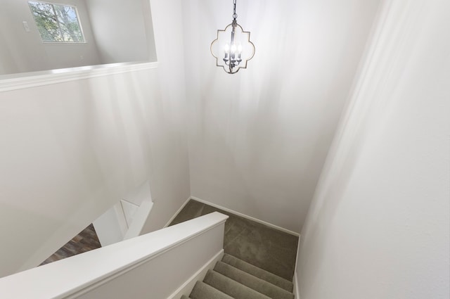 stairway featuring carpet and an inviting chandelier