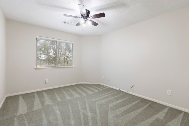 carpeted empty room featuring ceiling fan and a textured ceiling