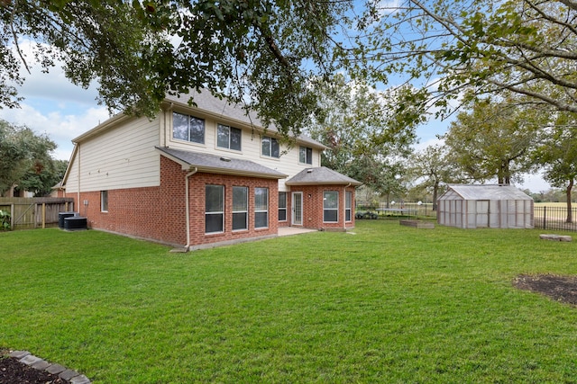 rear view of house featuring an outbuilding, a yard, and central AC