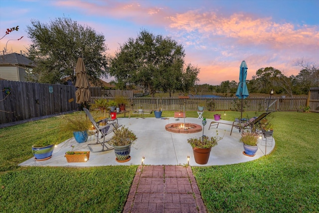 yard at dusk with a fire pit and a patio area