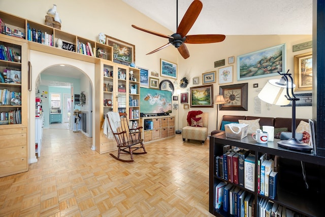 living area featuring a textured ceiling, ceiling fan, lofted ceiling, and parquet flooring