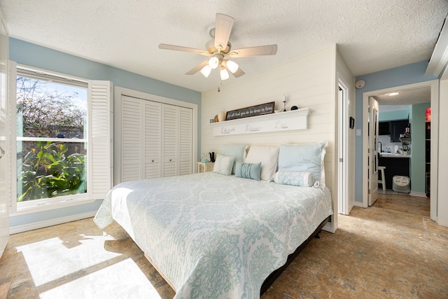 bedroom featuring ceiling fan, a closet, and a textured ceiling