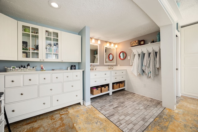 bathroom featuring vanity, a textured ceiling, and concrete floors