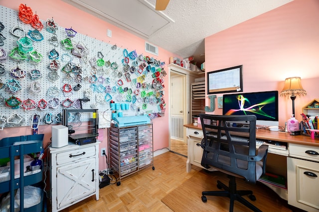 home office with a textured ceiling and light parquet floors