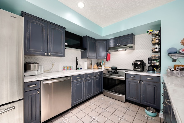 kitchen with sink, stainless steel appliances, light stone counters, decorative backsplash, and light tile patterned flooring