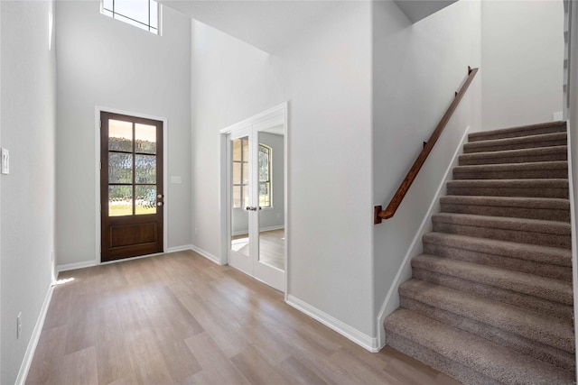 entryway with a towering ceiling and light hardwood / wood-style floors