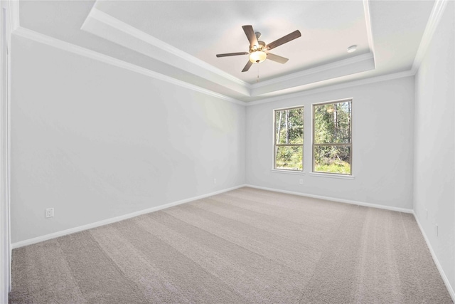 unfurnished room with a tray ceiling, ceiling fan, crown molding, and carpet floors