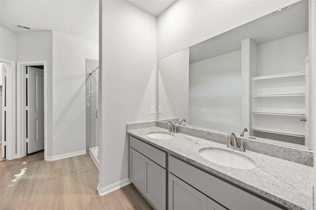 bathroom with hardwood / wood-style floors, vanity, and walk in shower