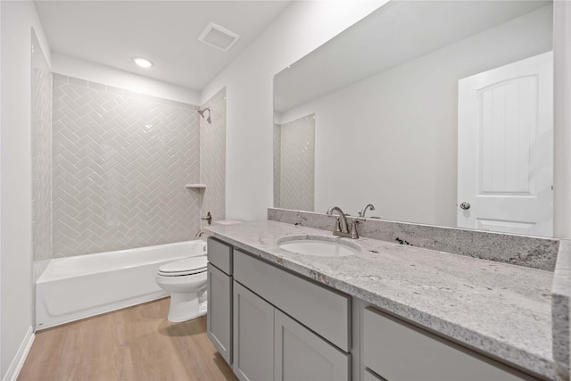 full bathroom with hardwood / wood-style floors, vanity, toilet, and shower / bath combination