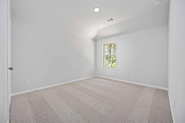 empty room with carpet flooring and vaulted ceiling