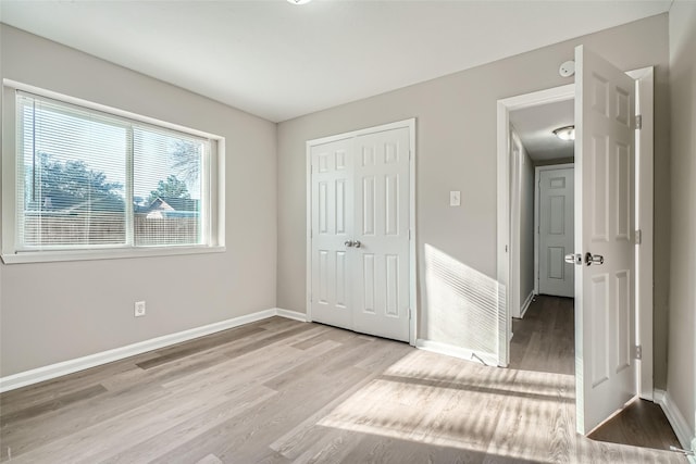 unfurnished bedroom with a closet and light wood-type flooring