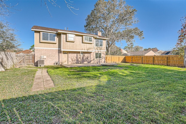 back of property with a yard, a patio, and central air condition unit