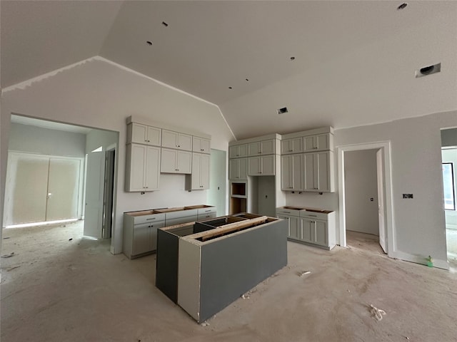 kitchen featuring lofted ceiling, a kitchen island, and gray cabinetry