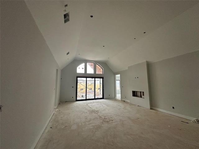 unfurnished living room with high vaulted ceiling