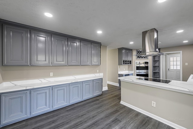 kitchen featuring dark hardwood / wood-style floors, double oven, island exhaust hood, gray cabinets, and black electric stovetop