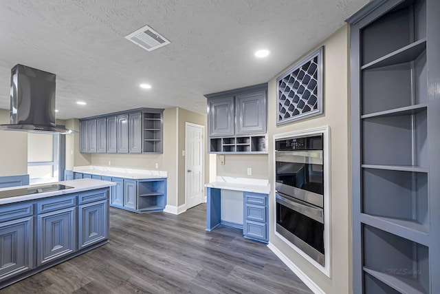 kitchen featuring a textured ceiling, black electric cooktop, dark hardwood / wood-style flooring, and wall chimney range hood