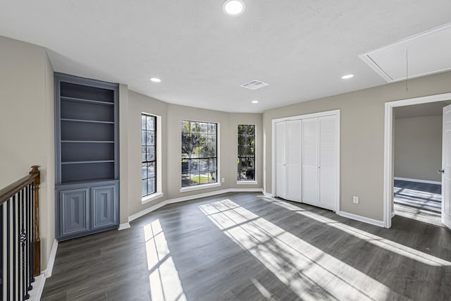 unfurnished bedroom with dark hardwood / wood-style floors and a closet