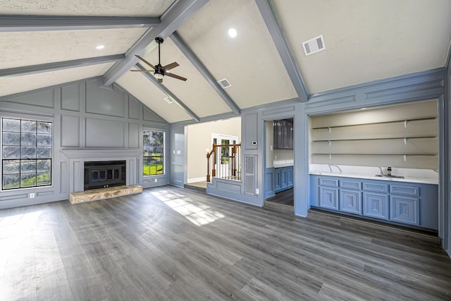 unfurnished living room featuring beam ceiling, ceiling fan, dark hardwood / wood-style flooring, and high vaulted ceiling