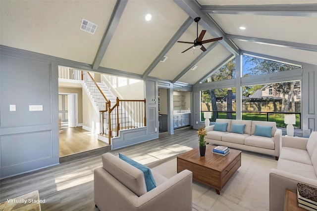 sunroom featuring lofted ceiling with beams, ceiling fan, and a wealth of natural light