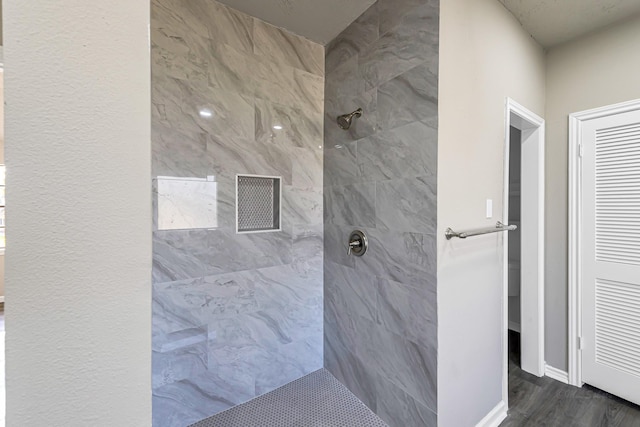 bathroom with hardwood / wood-style floors and tiled shower