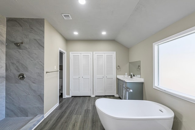 bathroom with hardwood / wood-style floors, vanity, vaulted ceiling, and shower with separate bathtub