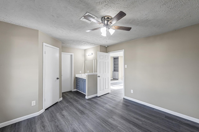 interior space featuring ceiling fan, dark hardwood / wood-style flooring, and a textured ceiling