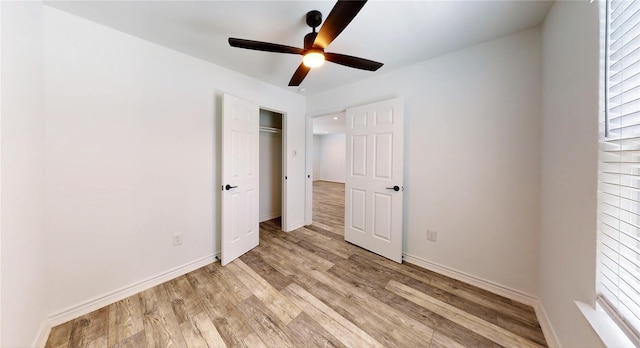 unfurnished bedroom with ceiling fan, light wood-type flooring, and a closet