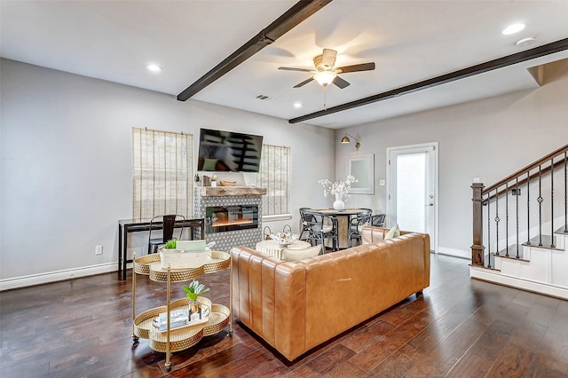 living room featuring beamed ceiling, ceiling fan, and dark wood-type flooring