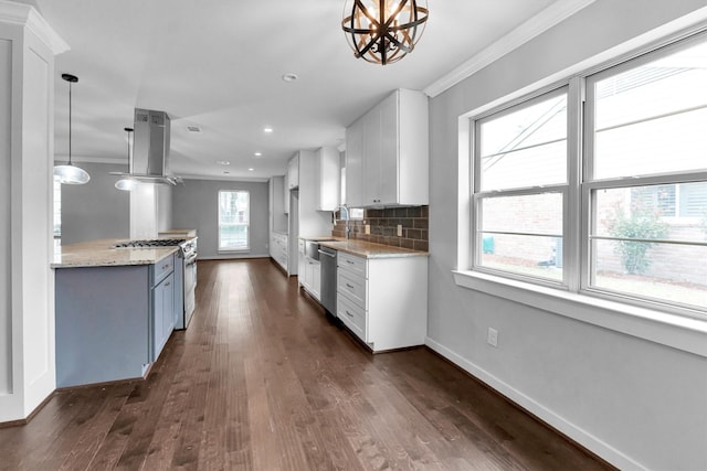 kitchen with stainless steel appliances, white cabinetry, ornamental molding, decorative backsplash, and hanging light fixtures