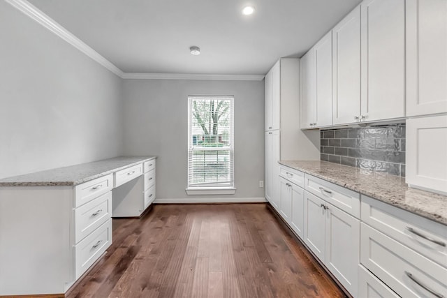 kitchen with light stone countertops, white cabinetry, dark wood-type flooring, and built in study area