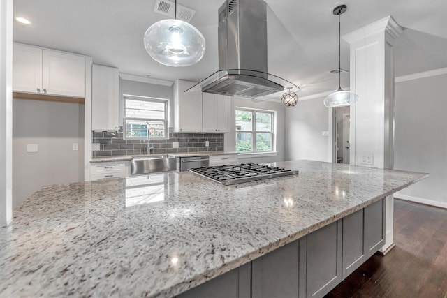 kitchen featuring light stone countertops, pendant lighting, and island range hood