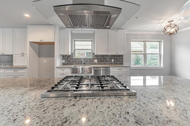 kitchen featuring light stone countertops, stainless steel appliances, crown molding, white cabinetry, and sink