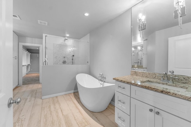 bathroom featuring independent shower and bath, hardwood / wood-style floors, and vanity