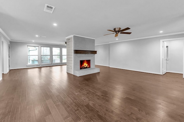 unfurnished living room with dark hardwood / wood-style flooring, a fireplace, ceiling fan, and crown molding