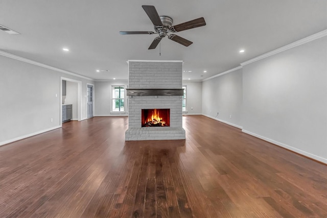 unfurnished living room with a fireplace, ceiling fan, crown molding, and dark hardwood / wood-style floors