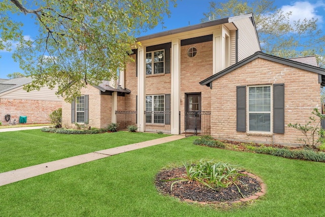 view of front of property featuring brick siding, stone siding, and a front yard