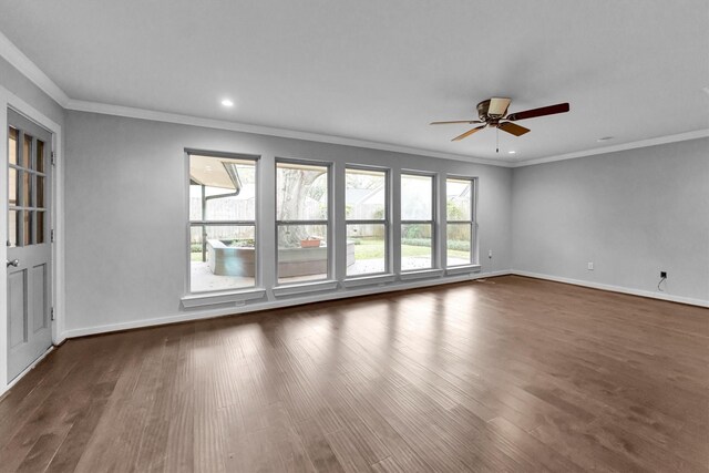 empty room featuring dark wood-type flooring, ceiling fan, and crown molding