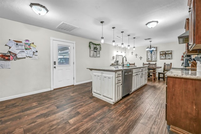 kitchen with sink, hanging light fixtures, light stone counters, stainless steel dishwasher, and a center island with sink